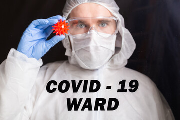 Covid-19, Vaccine development and medicine concept - Man scientist or doctor dressed personal protective equipment and holding a model of coronavirus.