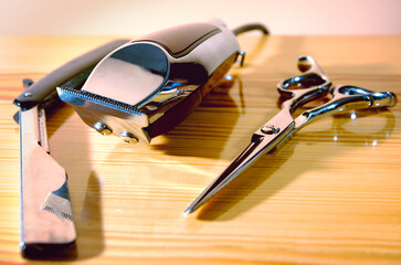 CUTTING TOOLS OF A BARBER ON WOODEN BACKGROUND