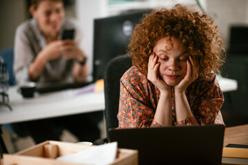 Tired businesswoman working on laptop. Young businesswoman working in the office..