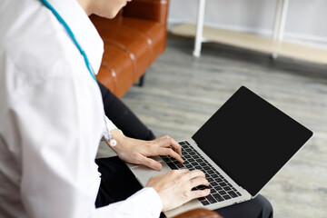 Male doctor in uniform are using laptops for medical work at modern hospital. empty monitor for your design. Laptop mockup.