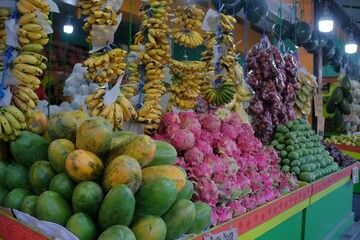 Various fruits such as papaya, dragon fruit, banana, are neatly displayed in a trading booth