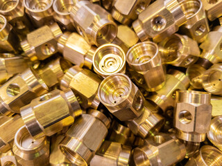 shiny brass parts background, chaotic disorder pile in close-up view with selective focus and...