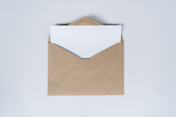 Blank white paper is placed on the open brown paper envelope. Mock-up of horizontal blank greeting...
