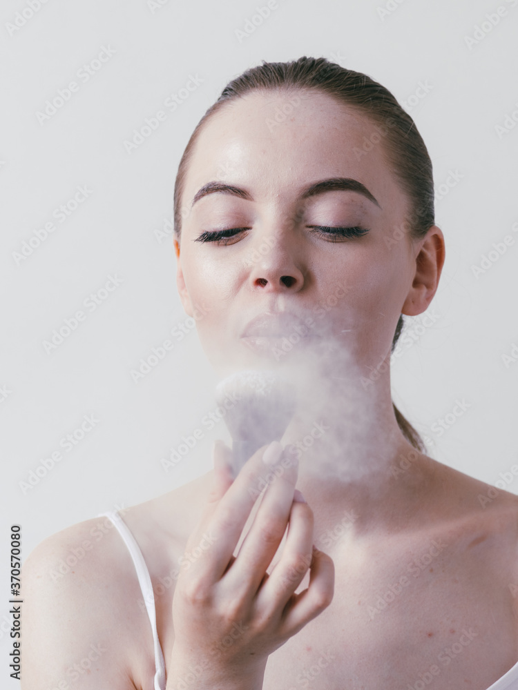 Wall mural woman applying powder on face cosmetic make up brush