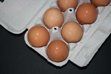 brown eggs in the box on a black background