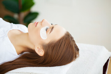 Obraz na płótnie Canvas Eyelash extension procedure, professional stylist lengthening female lashes.