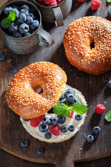 Sweet bagel with raspberries and blueberries for quick lunch