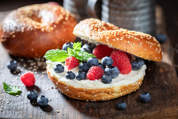 Homemade bagel with raspberries and blueberries for healthy breakfast