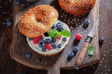 Sweet bagel with raspberries and blueberries for healthy breakfast