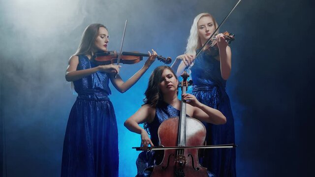 String trio. Women playing on violins and cello at concert