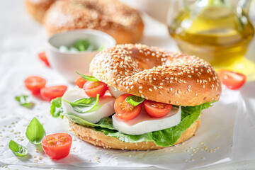 Homemade bagel with cheese, tomatoes and basil for healthy lunch