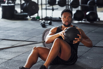 Strong african american man in sportive clothes have workout day in the gym