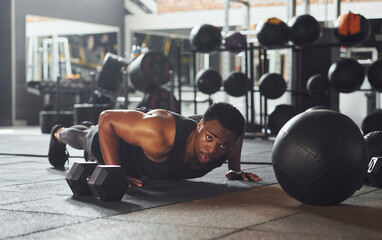 Strong african american man in sportive clothes doing push-ups in the gym