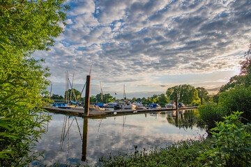 Small jetty with some boats on weser at beautiful sunset and sky in bremen