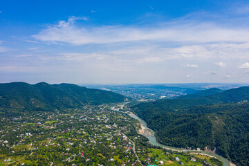 Fototapeta na wymiar Aerial drone view of green mountain, pine forest, river and village. Vyzhnytsya, Carpathian, Ukraine.