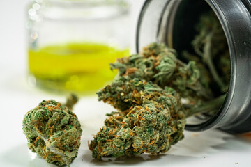 Close up of a heap medical marijuana buds and cannabis oil on white background