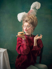 Such a welcome burger. Young woman as Marie Antoinette on dark green background. Retro style,...
