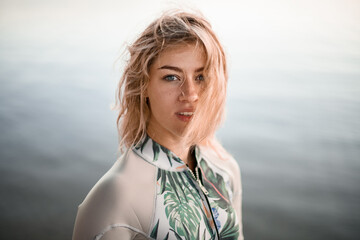 portrait of young beautiful blonde woman with wet hair in gray wetsuit