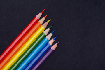 Colour pencils on black background close up