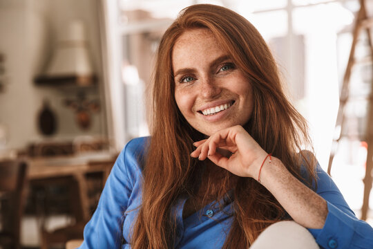 Image of happy ginger woman smiling and looking at camera