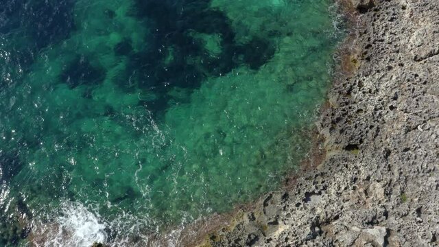 AERIAL: Birds View of beautiful Ocean Blue Water on Rock Coast on Tropical Island Mallorca, Spain Vacation, Travel, Sunny, Waves 