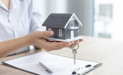 Asian woman sells the house and signs a contract.