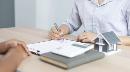Asian woman sells the house and signs a contract.