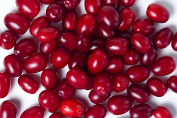Dogwood on a white background. Fresh red dogwood lies in a small heap. Gathering the summer harvest.