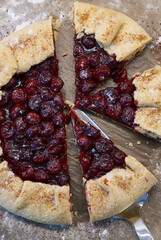 Summer homemade galette with cherries on parchment paper. Summer French open pie.     