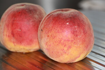 ripe peaches on a metallic silver background