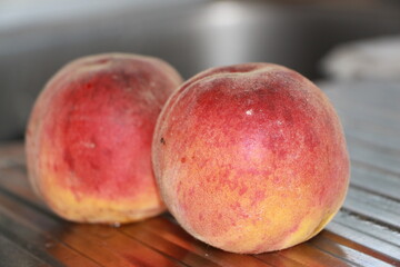 ripe peaches on a metallic silver background