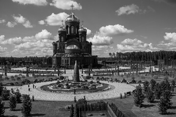 panoramic view of a dark temple with golden domes against a background of gray clouds