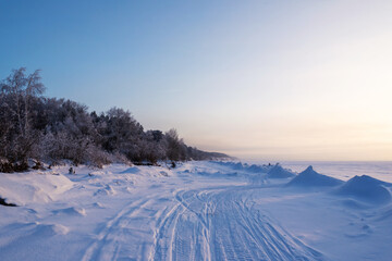 Fototapeta na wymiar Winter road along a frozen lake