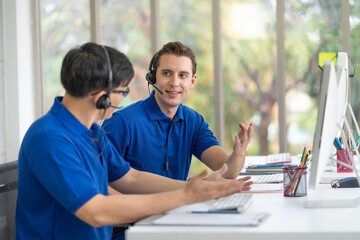 Call center man in blue shirt uniform discussing with colleagues at call center office