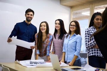 Portrait of cheerful architect group standing together in office celebrating completing work on project .Skilled team of young employees satisfied with teamwork achievement in designing graphic
