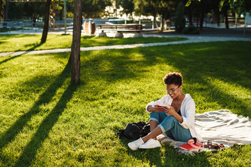 Woman sitting outdoors and using mobile phone