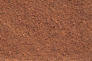 Dry coffee sediment, texture of ground bean, cracks on the surface.