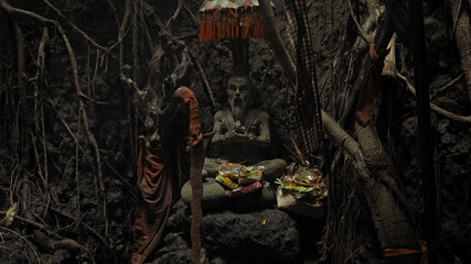 Religious place for rites with ancient statues of people in a dark cave with strong shadows