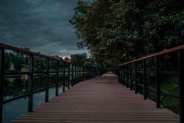 Fototapeta na wymiar Wooden walkway fenced with railings around Shitov Embankment 