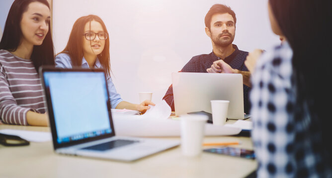 Group of creative designers planning working process for improving productivity while collaborating,skilled male and female students making presentation on laptop with mock up connected to 4G internet