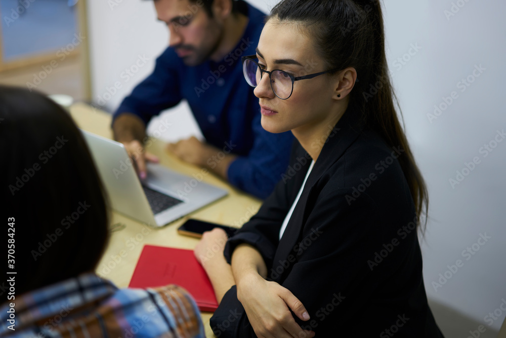 Aufkleber confident female student in eyeglasses thinking about improvements for coursework project while coll