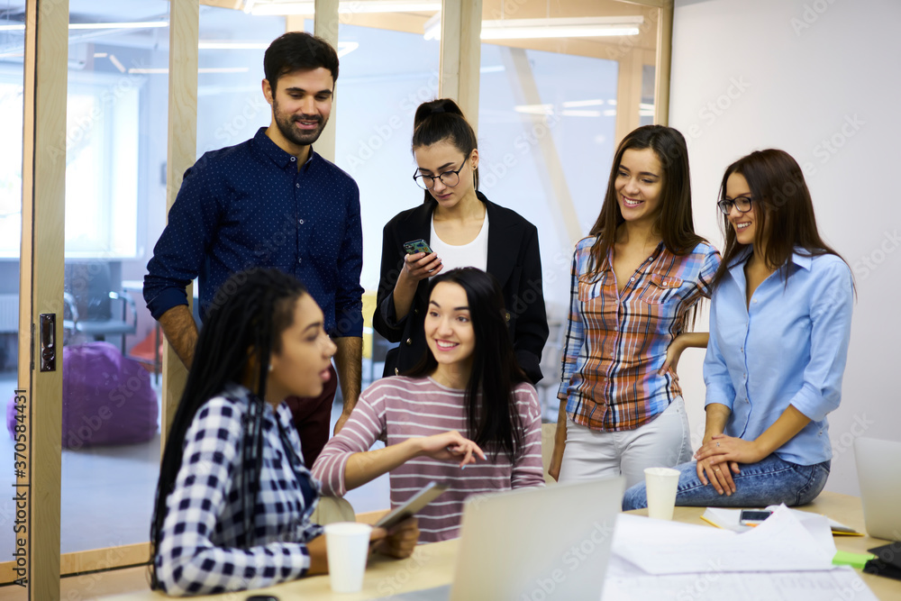 Poster multicultural group of skilled students of university discussing details about coursework project an