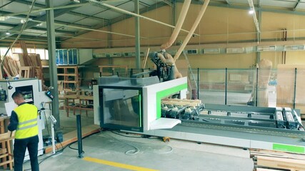 Automated machine works at woodworking plant.
