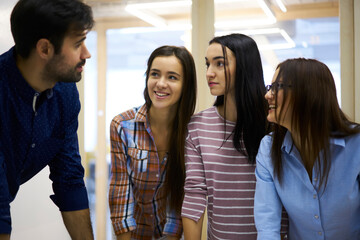 Bearded professional male manager explaining colleagues working process and making plans for startup project,crew of young engineers communicating with each other during work break standing in office