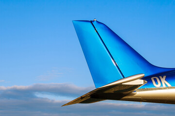 Tail of a small 2-seater aircraft against a blue sky. Close up.