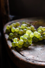 clusters of white grapes on the wooden background, freshly harvested green grapes in the village 