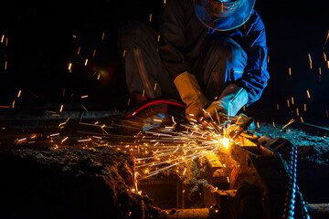 Worker cutting metal steels by Gas Cutting Torch. He cutting the iron chain in the confined spaced.