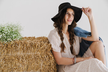 Beautiful smiling woman on haystack