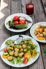 Round new potatoes fried to Golden brown with tomatoes, herbs and lettuce