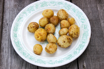 Round new potatoes fried to Golden brown with tomatoes, herbs and lettuce